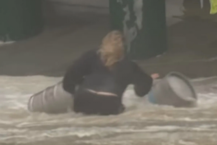 Mujer arriesga su vida en inundación para salvar barriles de cerveza