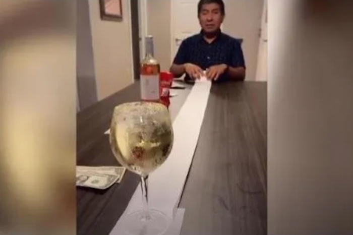 Familia se retan entre ellos a mover una copa de vino con un rollo de papel