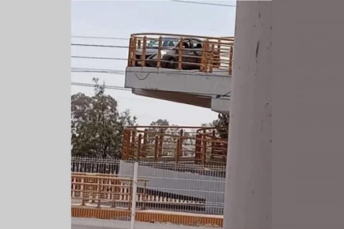 Auto se atora en puente peatonal y usuarios reaccionan