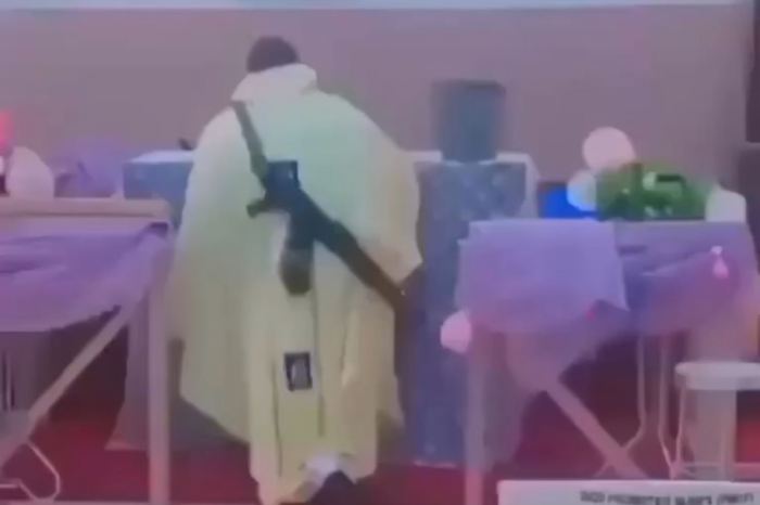 Sacerdote católico oficia misa con un rifle 